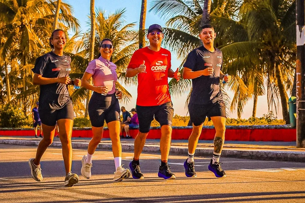 Quatro alunos da CORRE correndo juntos na Orla de Cabo Branco